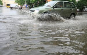 Car driving through flood water after a hurricane